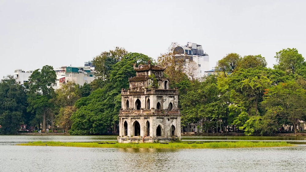 Morning in Hoan Kiem Lake awakens with golden reflections on tranquil water